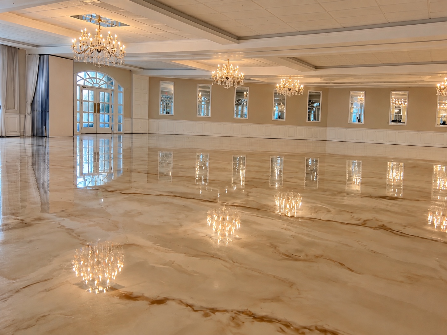 Salle de réception avec un plancher en époxy métallique beige et doré brillant.